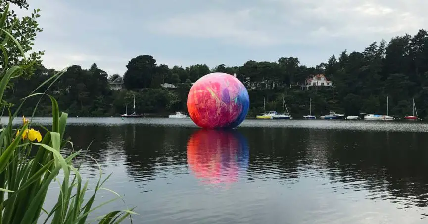 oeuvre art sur l'Erdre à Sucé-sur-Erdre : grande bulle ou balle flotte sur l'eau. Elle est pleine de couleurs vives - Oeuve du Parcours Voyage à Nantes en Loire-Atlantique